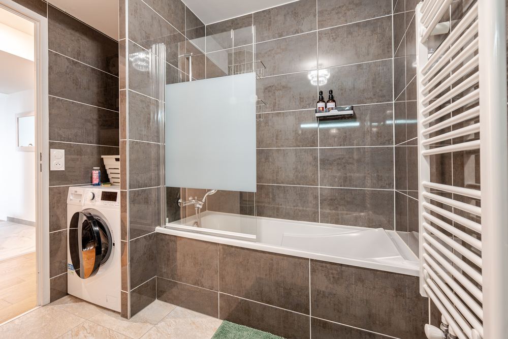 Bathroom with bathtub and washing machine